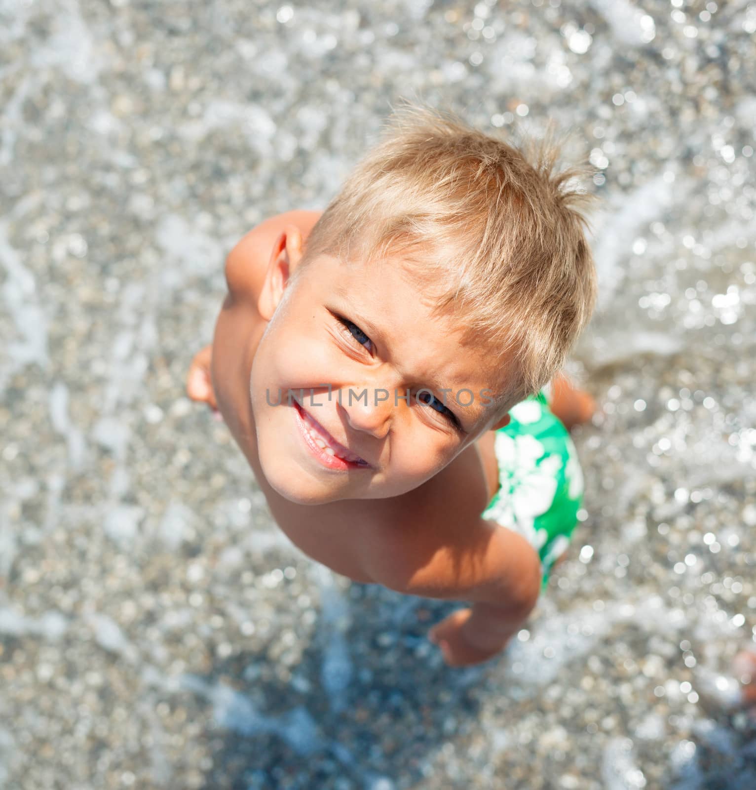 Playful boy on the beach with sea on background