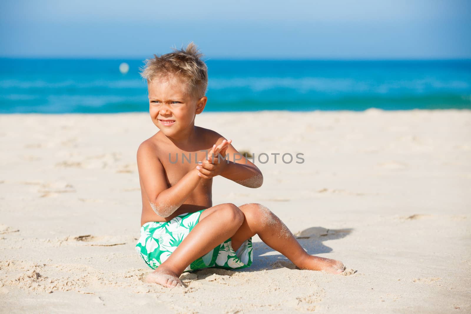 playful boy on the beach with sea on background