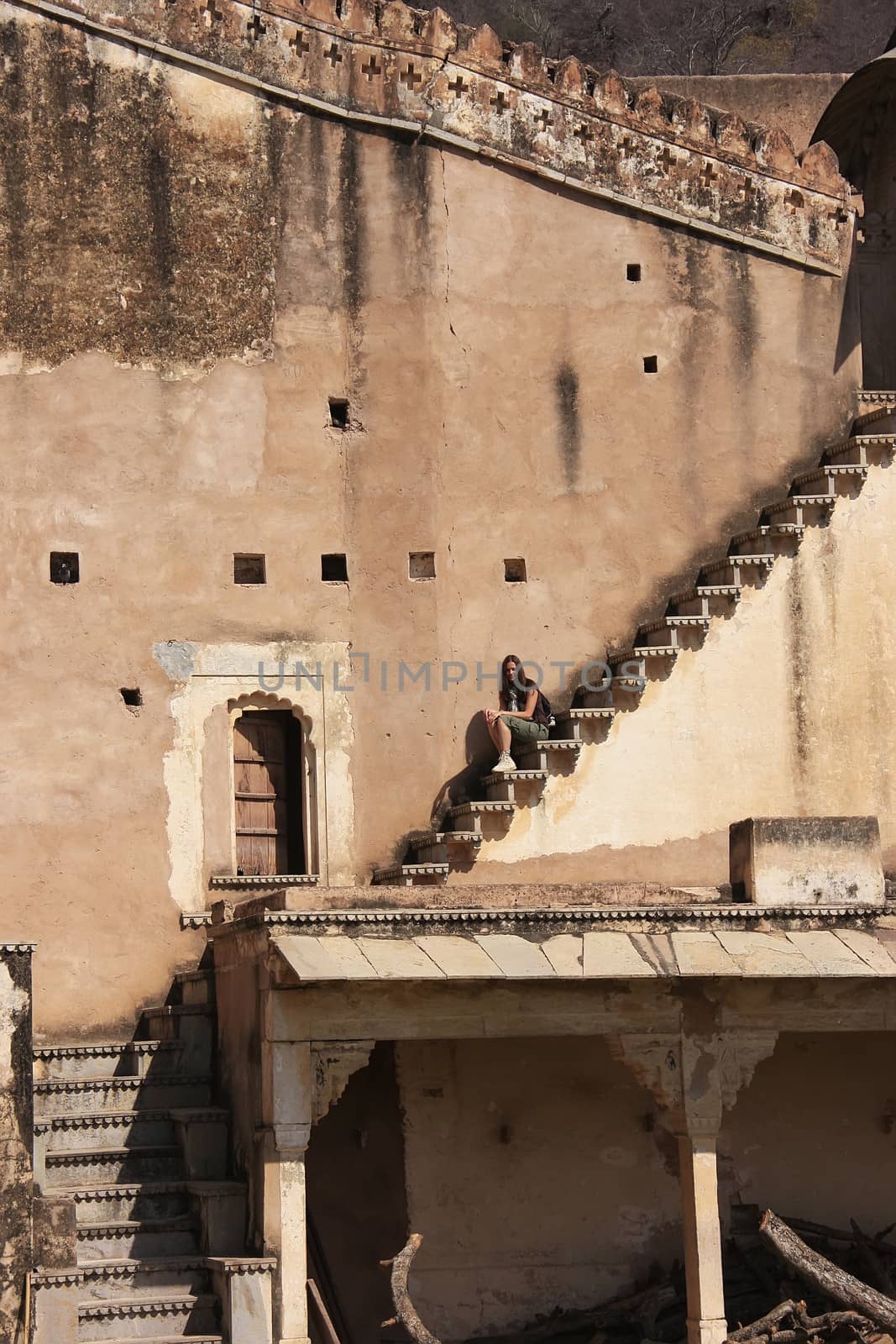 Young woman sitting on the stairs, Bundi Palace, Rajasthan, India