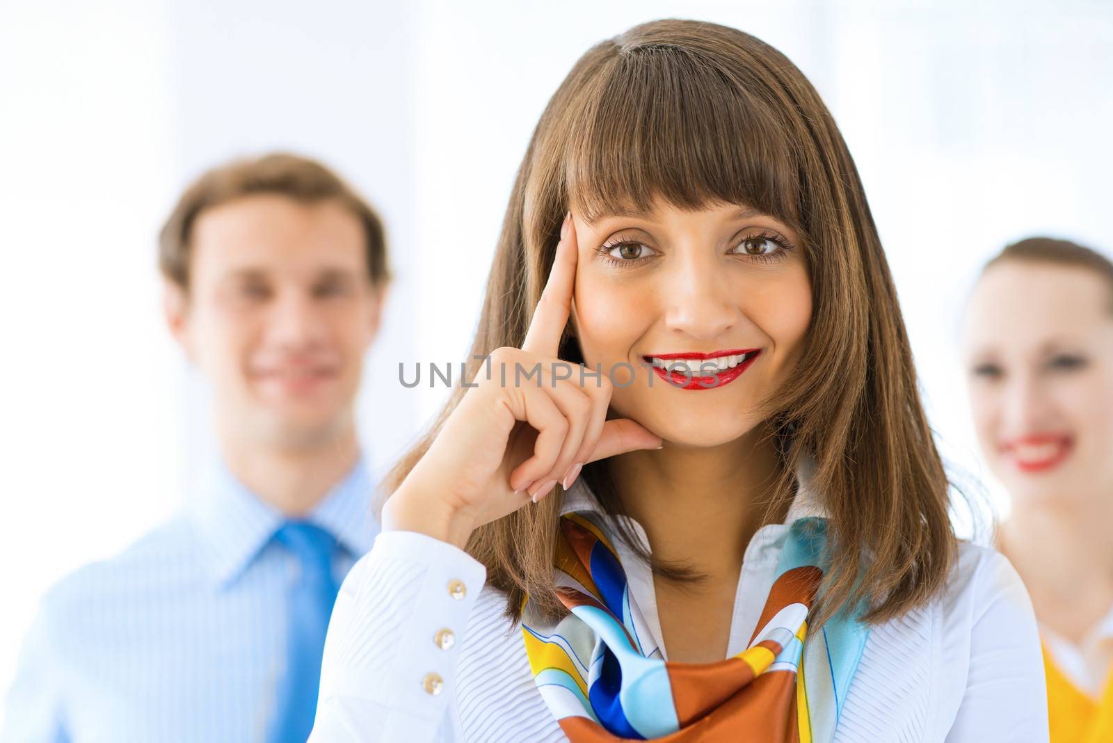 Portrait of a young successful business woman standing against colleagues