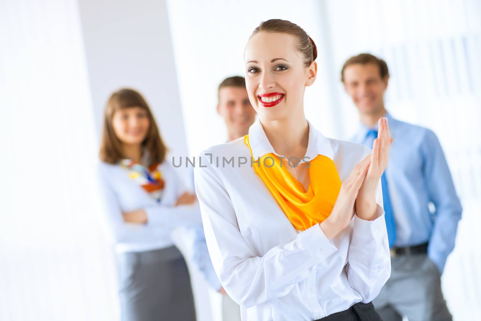 Portrait of a young successful business woman standing against colleagues