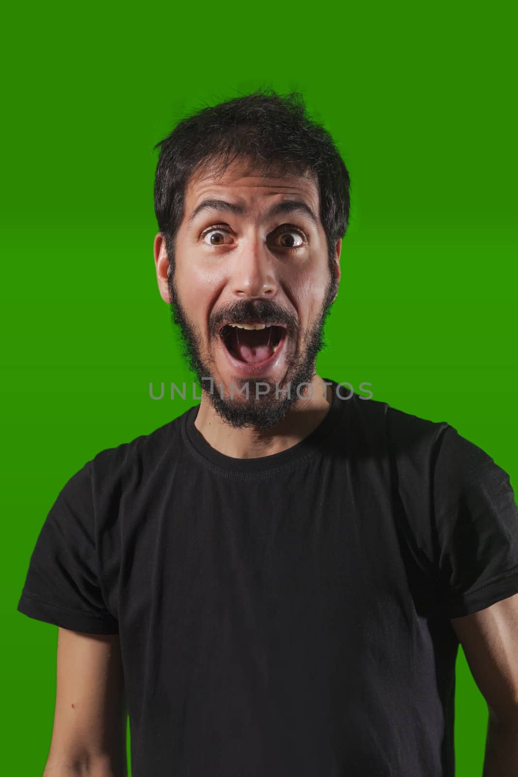 Young crazy man. Isolated over green background