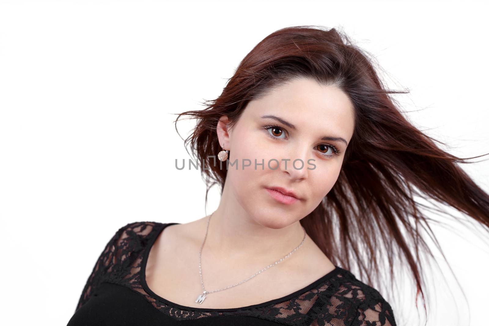 Fashion portrait of beautiful teenager girl with perfect skin and wind in hair on white background