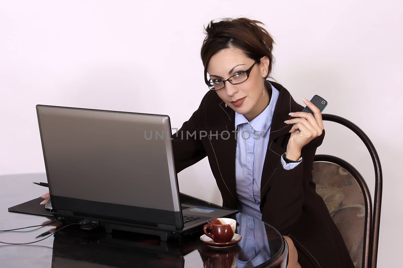 Young businesswoman sitting at desk by dukibu
