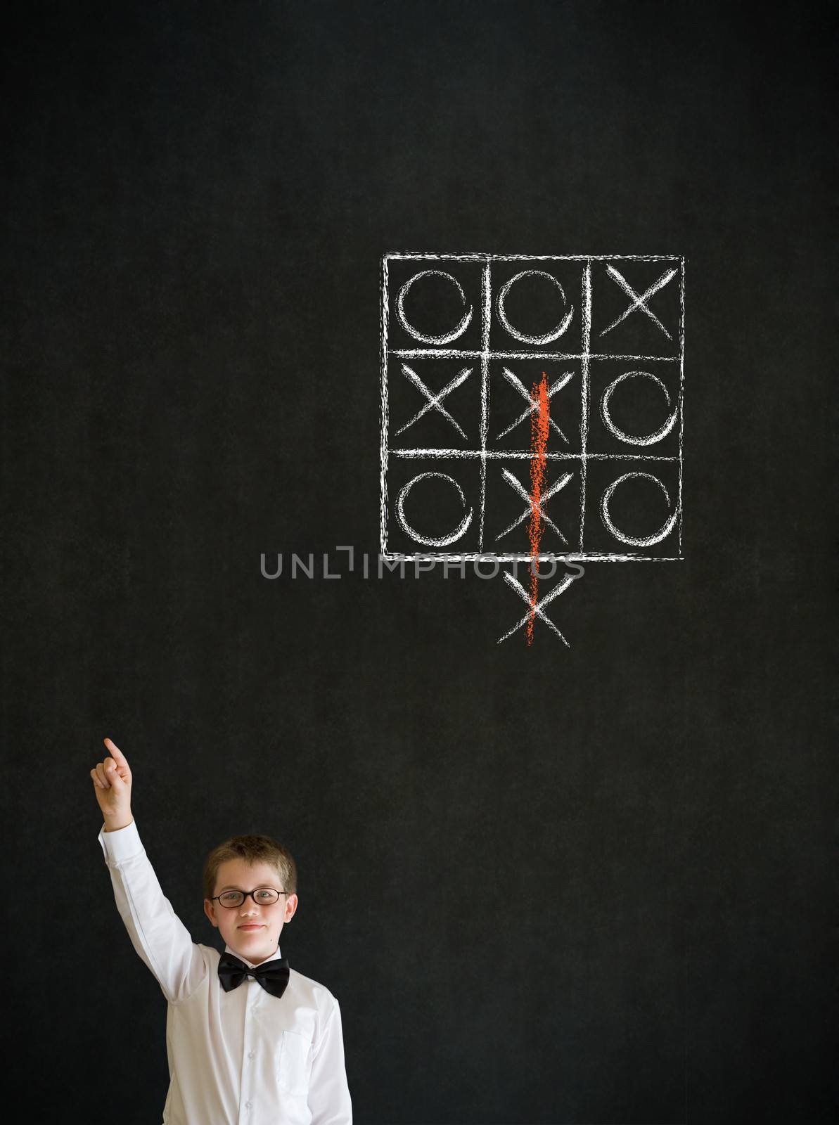 Hand up answer boy dressed up as business man with thinking out of the box tic tac toe concept on blackboard background