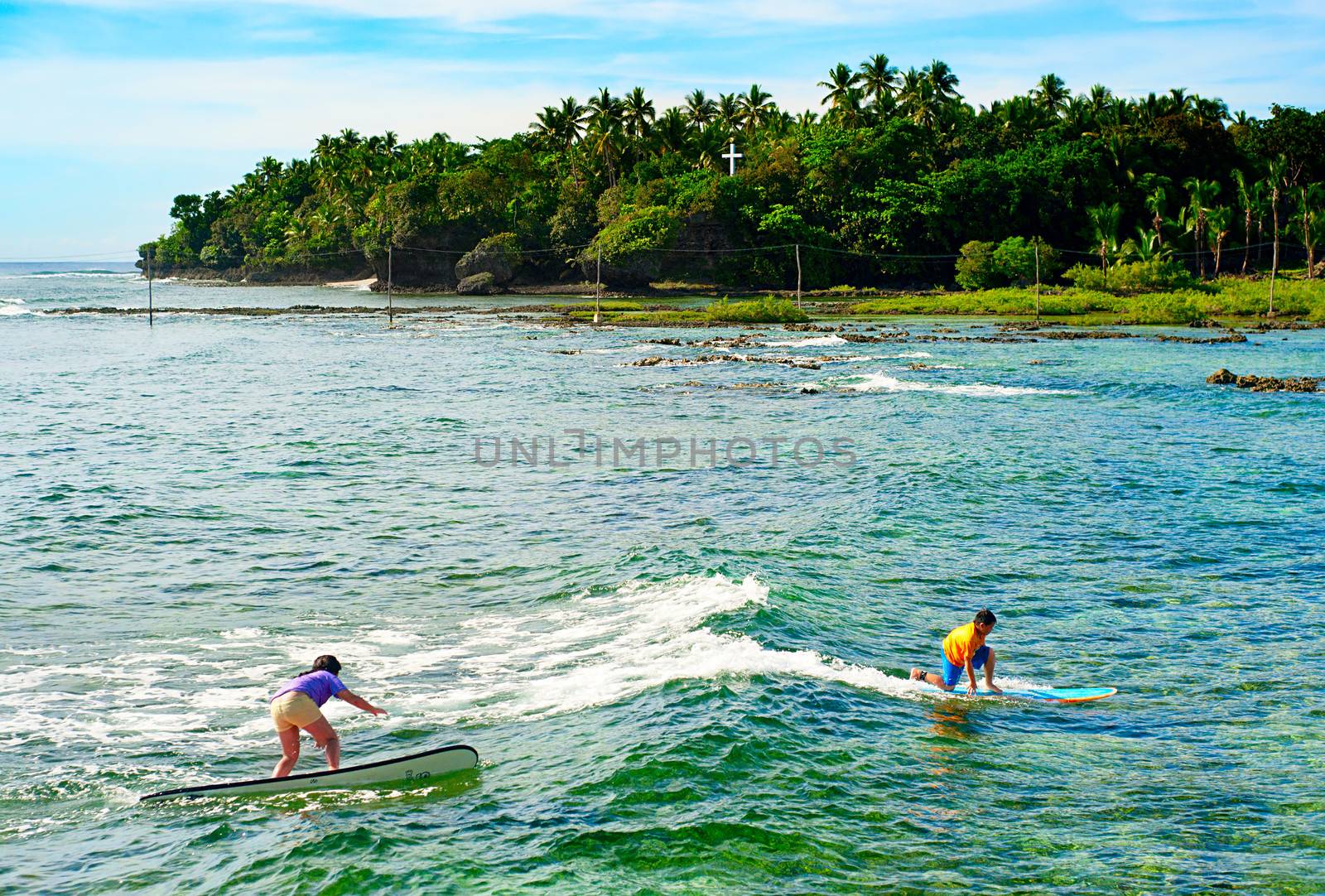 Siargao, Philippines -  May 11, 2013: Young people learning to surf at Cloud 9 surfpoint in Siargao.  In 2011 3.9 million tourists visiting the country.