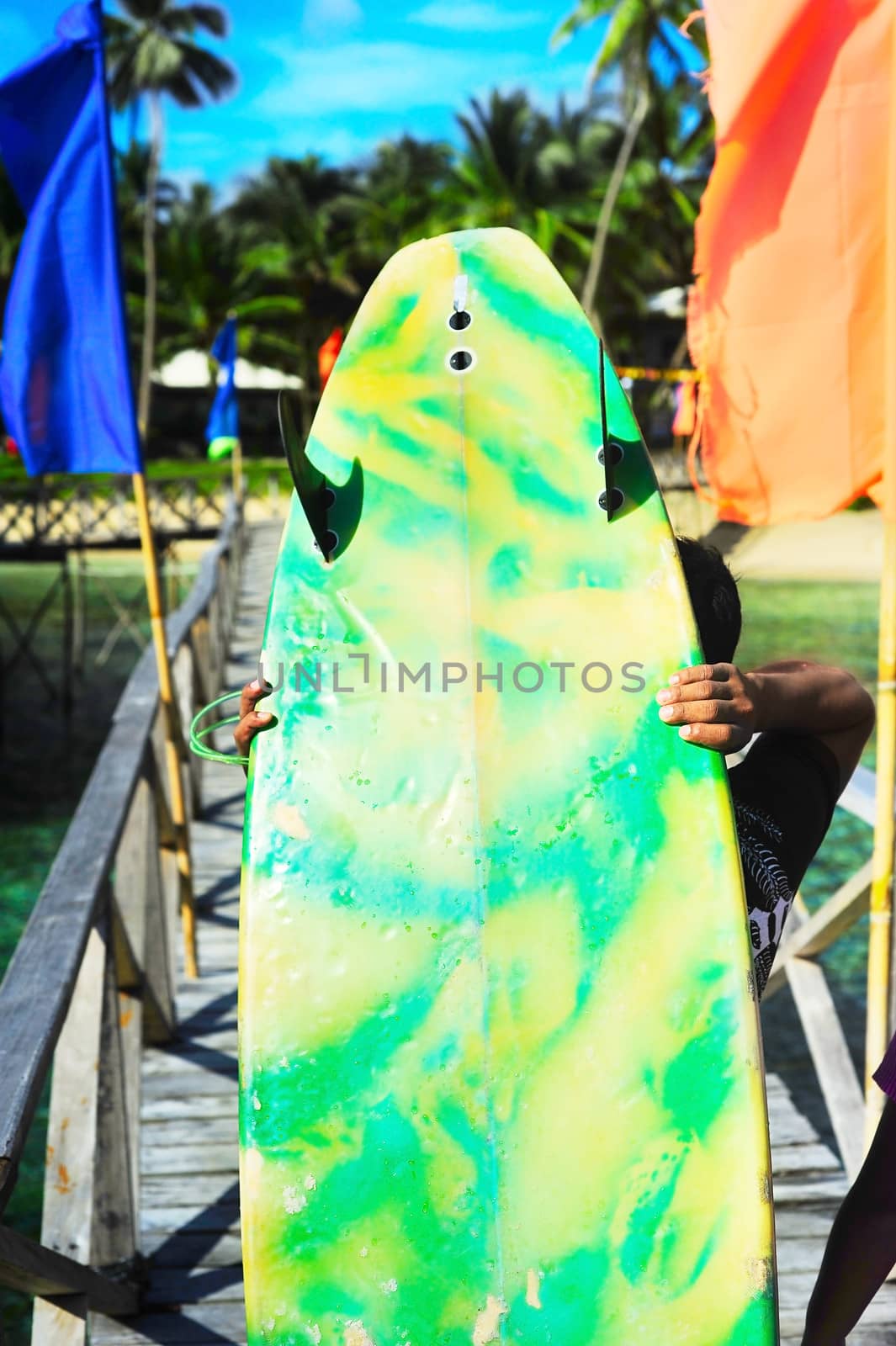 Young man walking with a surfboards at Cloud 9 surfpoint on Siargao island, Philippines