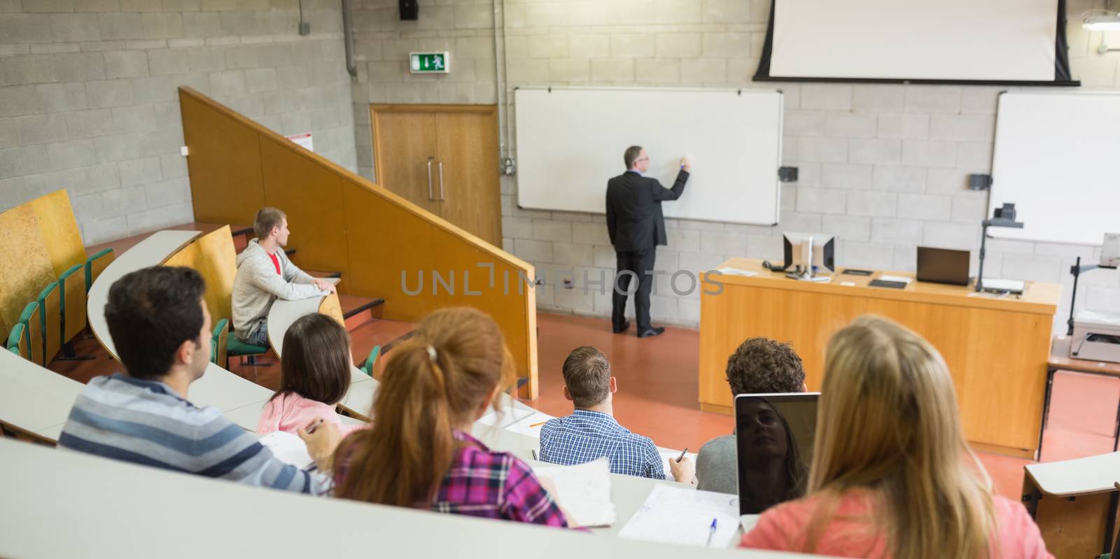 Male teacher with students at the lecture hall by Wavebreakmedia