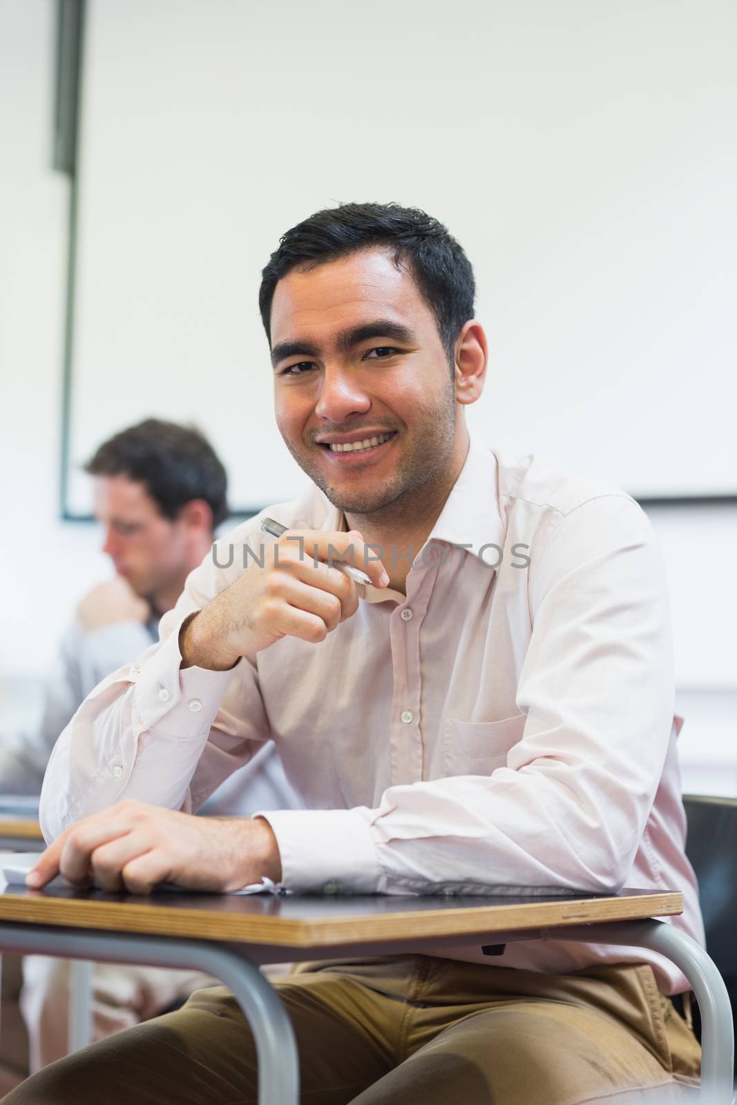 Mature students taking notes in classroom by Wavebreakmedia