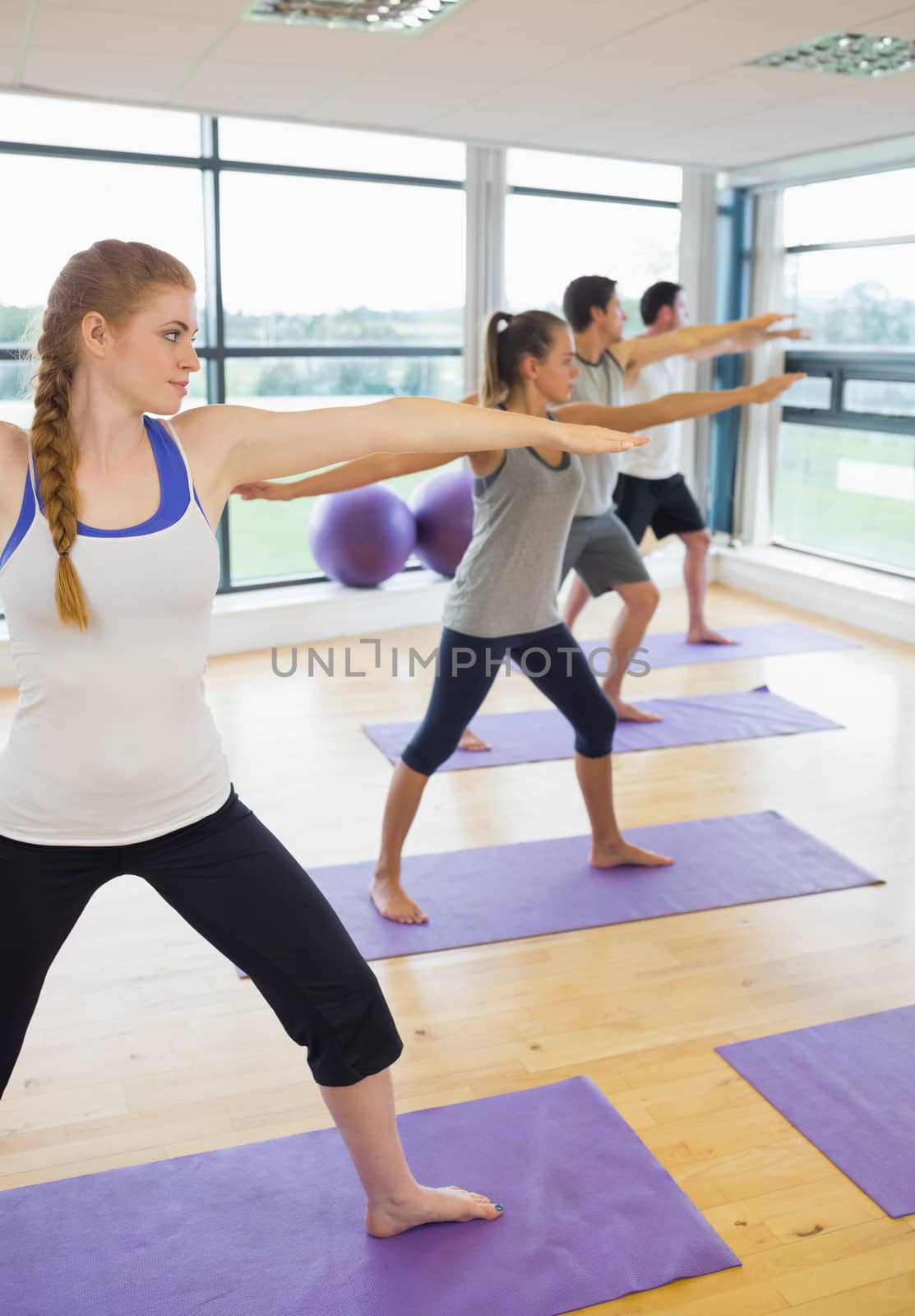 Sporty people stretching hands at yoga class by Wavebreakmedia