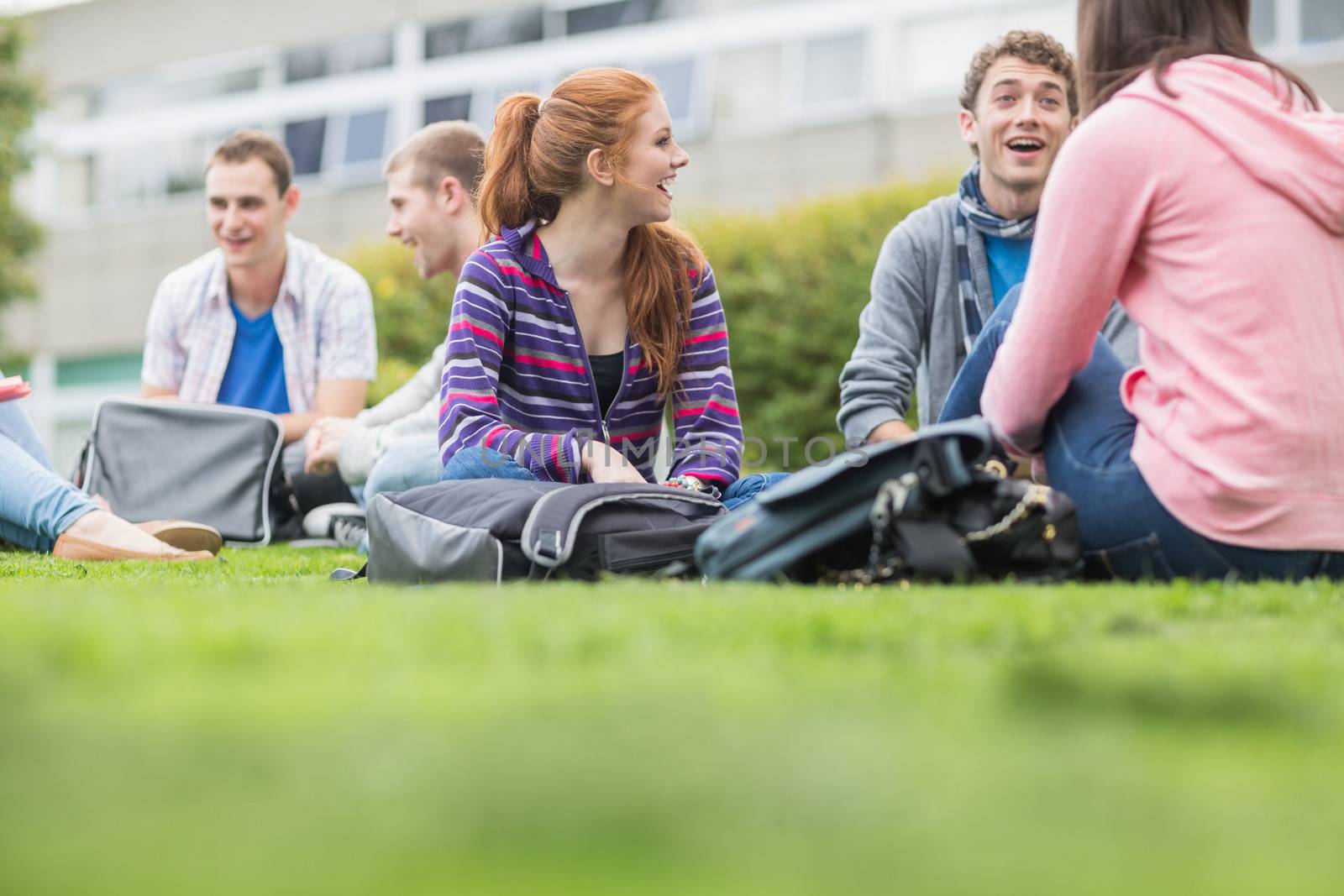 College students sitting in the park by Wavebreakmedia