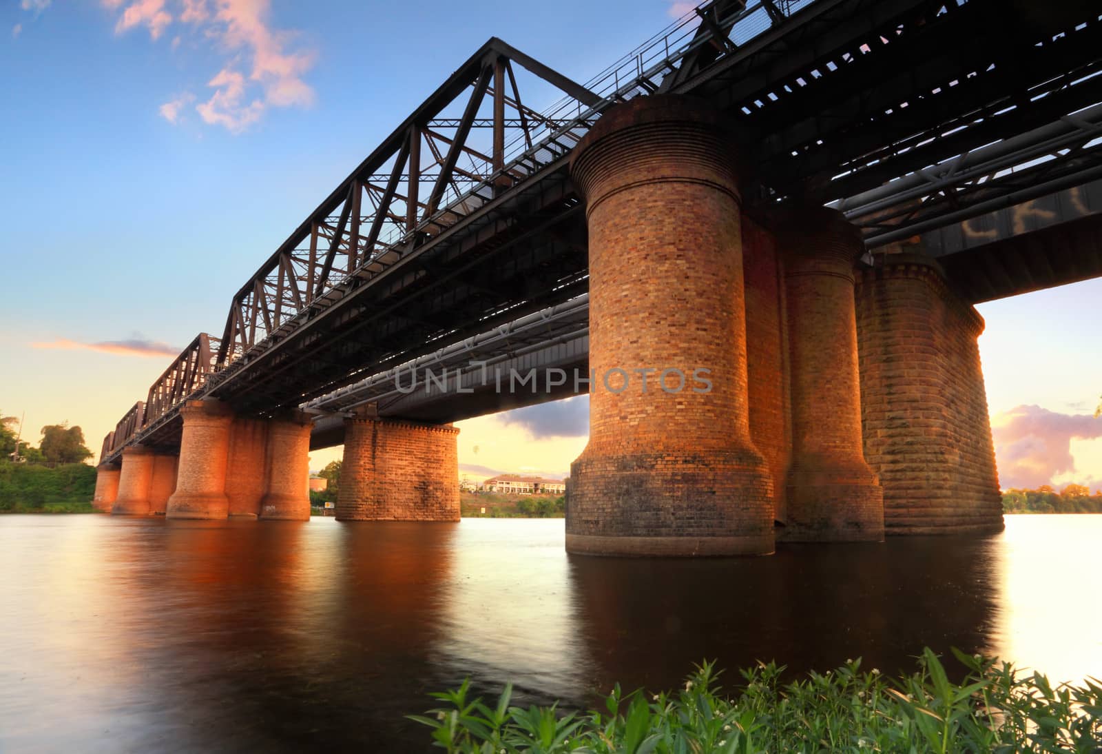 The Victoria Bridge Penrith, view from waters edge at sunset.  This is the old wrought iron and box plate girder bridge that crosses the Nepean River