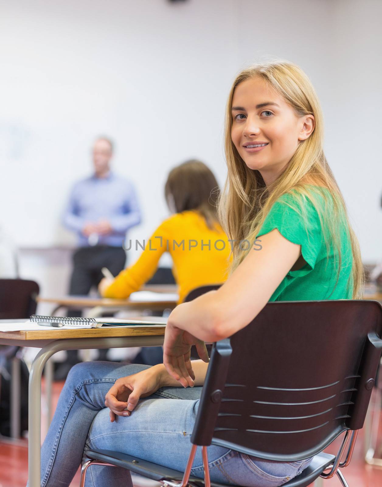 Female with blurred teachers students in classroom by Wavebreakmedia