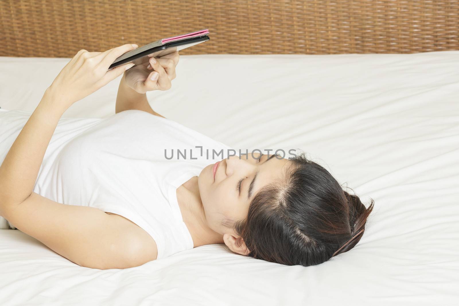 happy young asian woman lay down and working on tablet in bedroo by FrameAngel