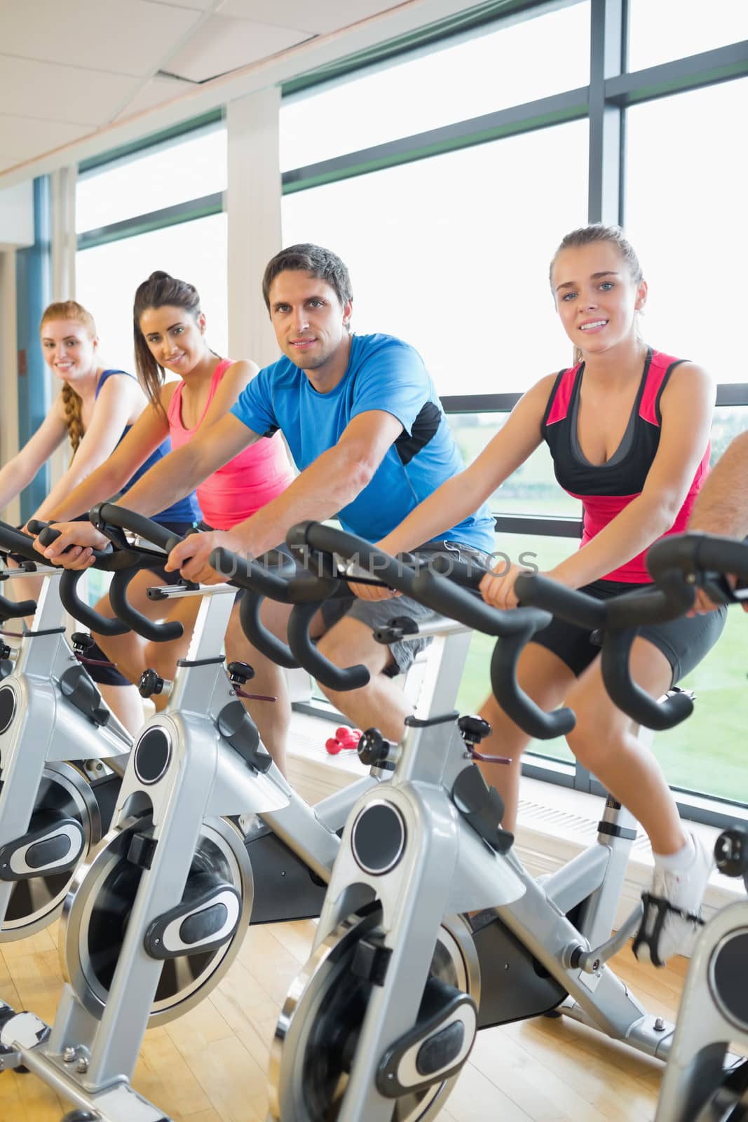 Four people working out at spinning class by Wavebreakmedia