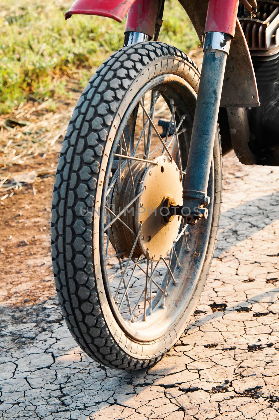 Old wheel motorcycle on a dirt road. 