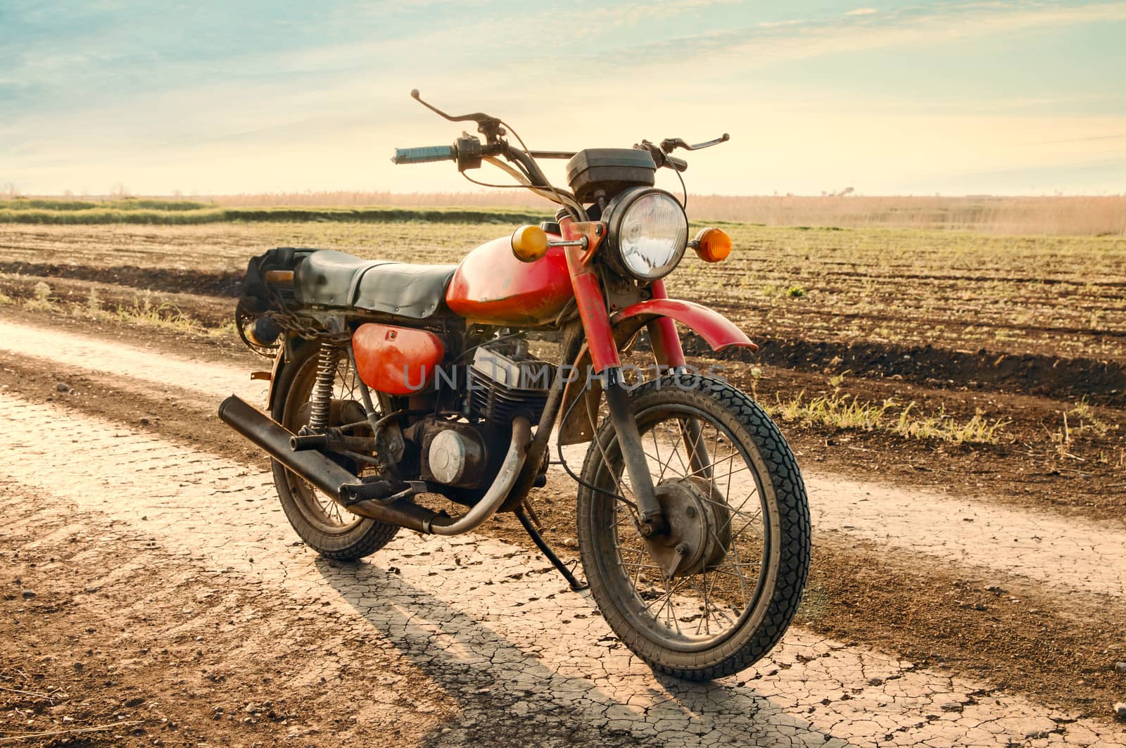 Classic old motorcycle on a dirt road. 