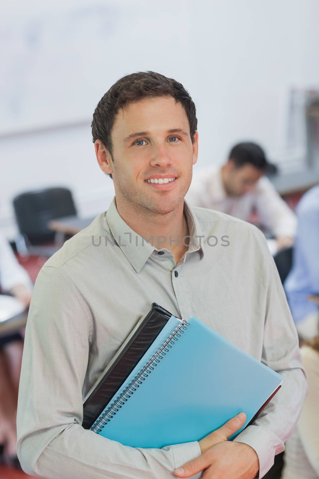 Handsome male teacher posing in his classroom by Wavebreakmedia