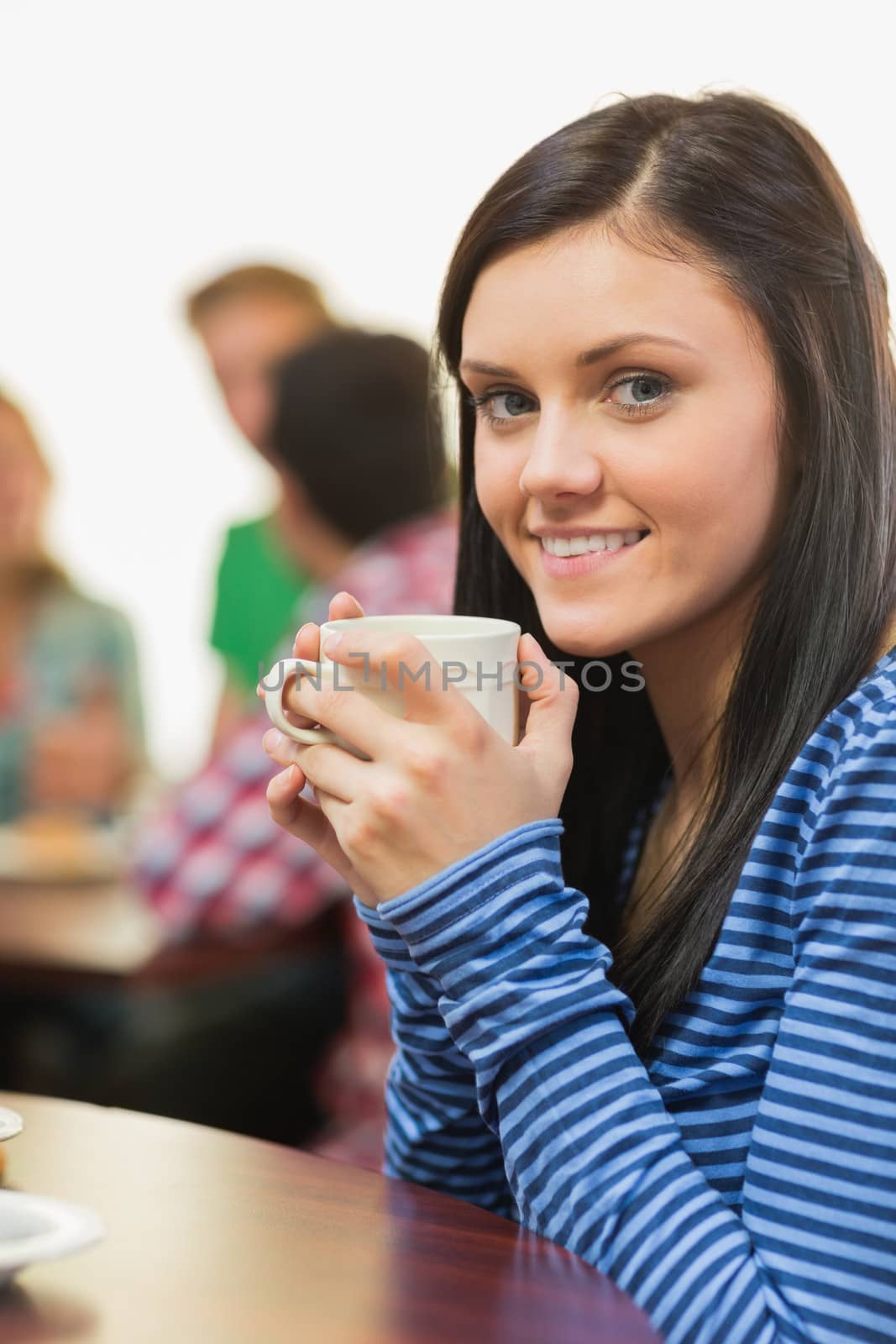 Portrait of a smiling female having coffee at  coffee shop by Wavebreakmedia