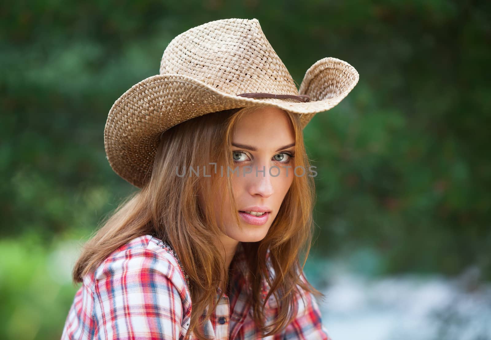 Sexy cowgirl. Young woman portrait in a hat