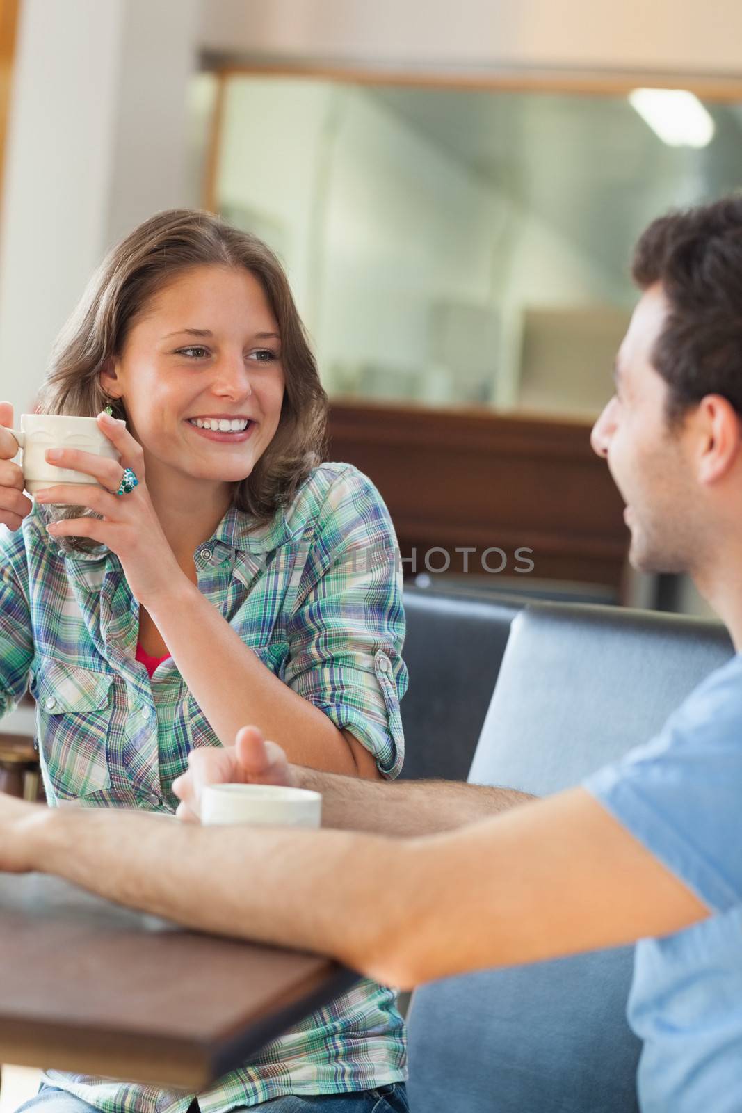 Two content students having a cup of coffee in college canteen