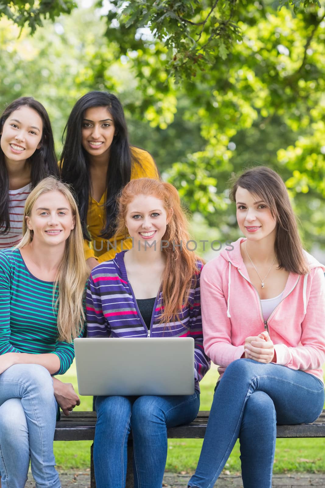 Young college girls with laptop in park by Wavebreakmedia