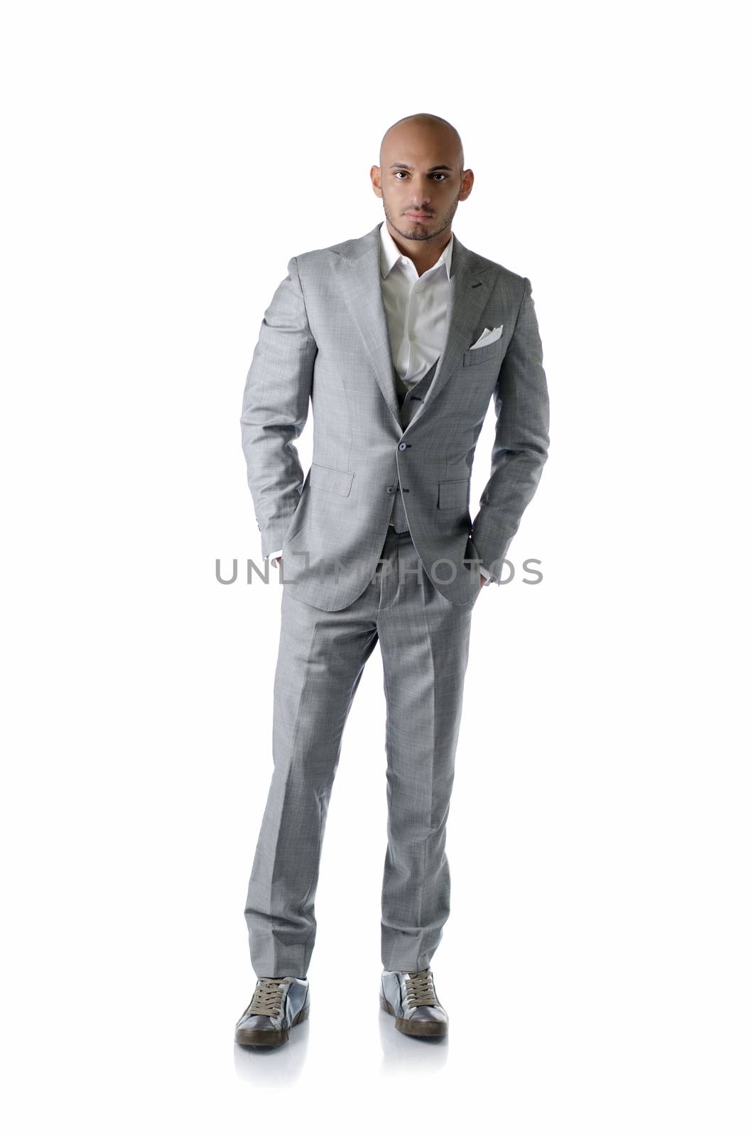 Full body shot of elegant, bald young man in business suit on white background, looking at camera