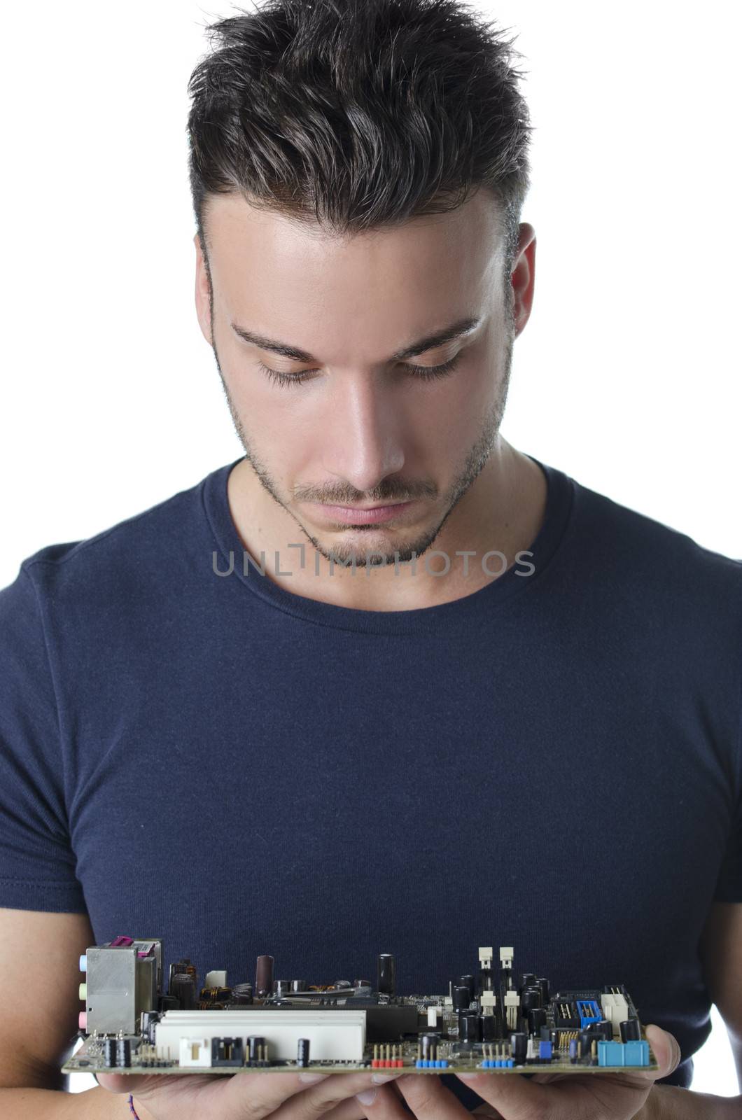 Confused, puzzled computer technician, a handsome young man, looking at motherboard