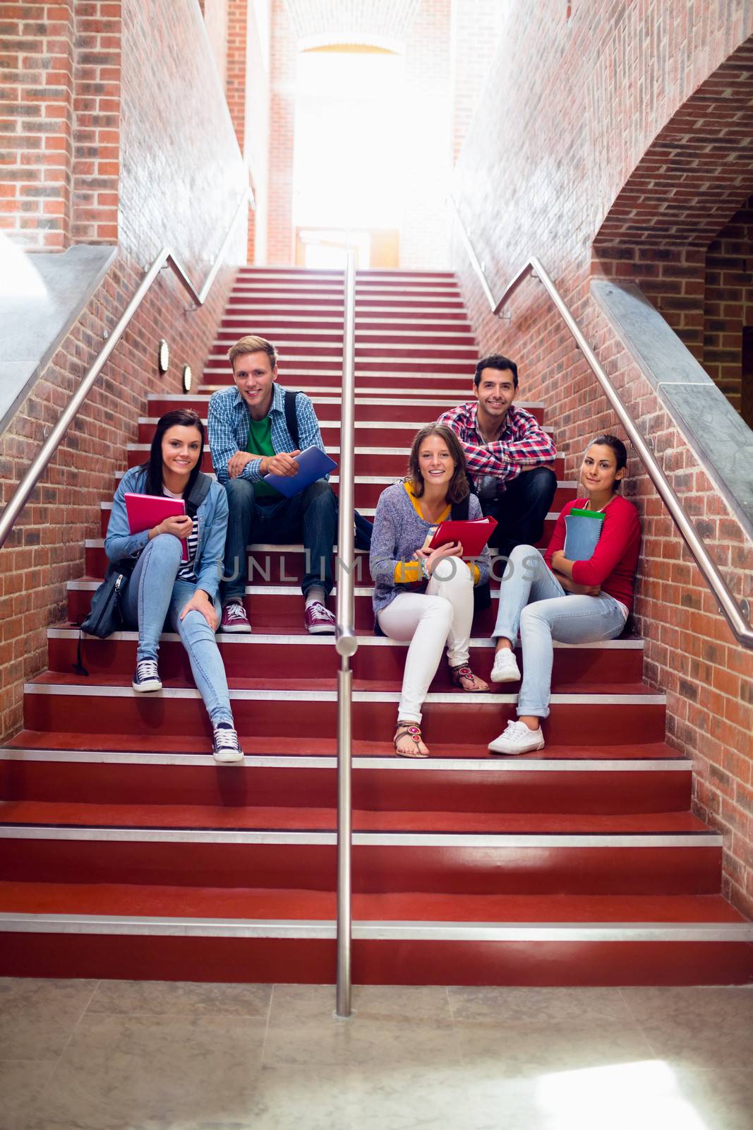 Group portrait of young college students sitting on stairs in the college