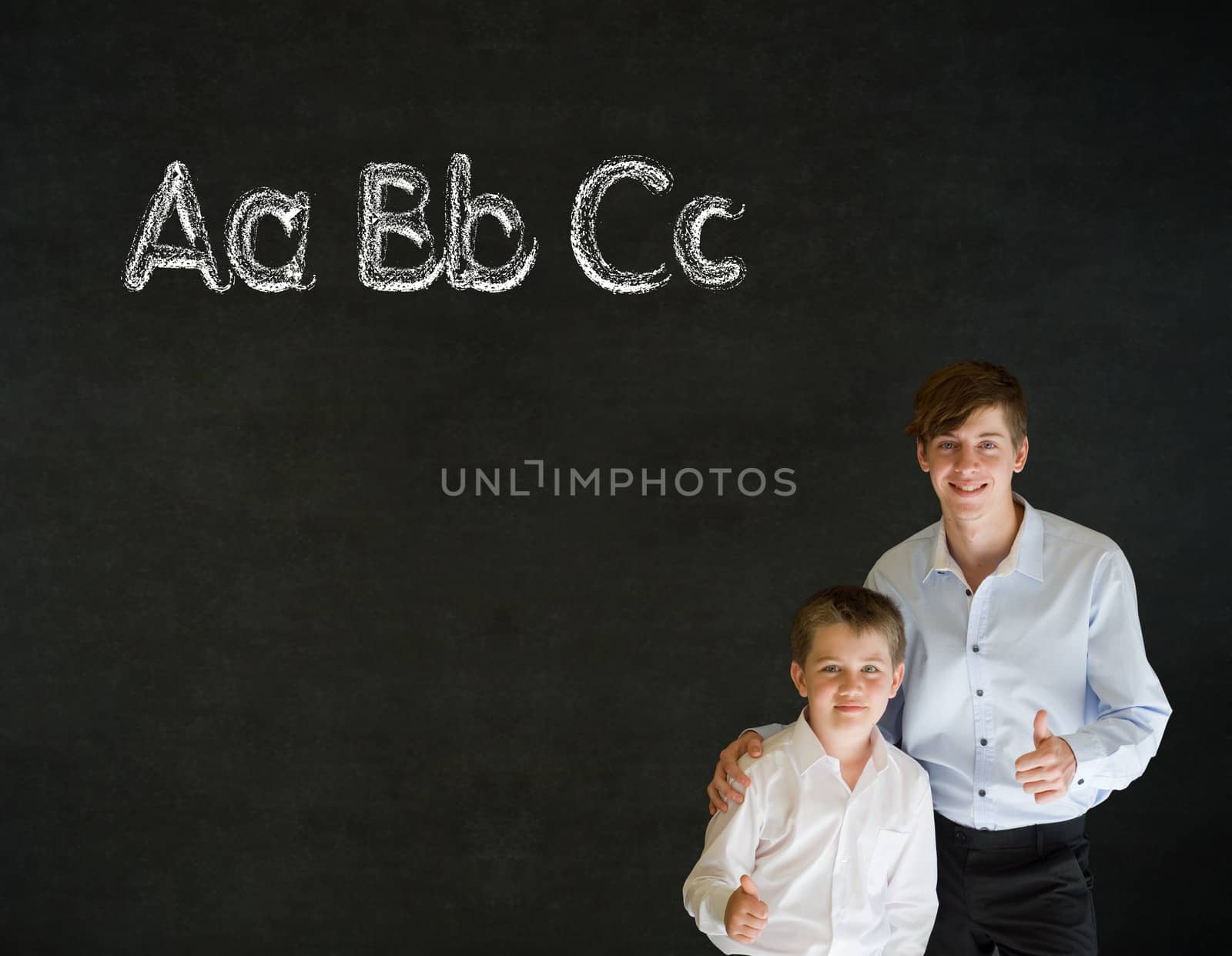 Thumbs up boy dressed up as business man with teacher man and learn English language alphabet on blackboard background