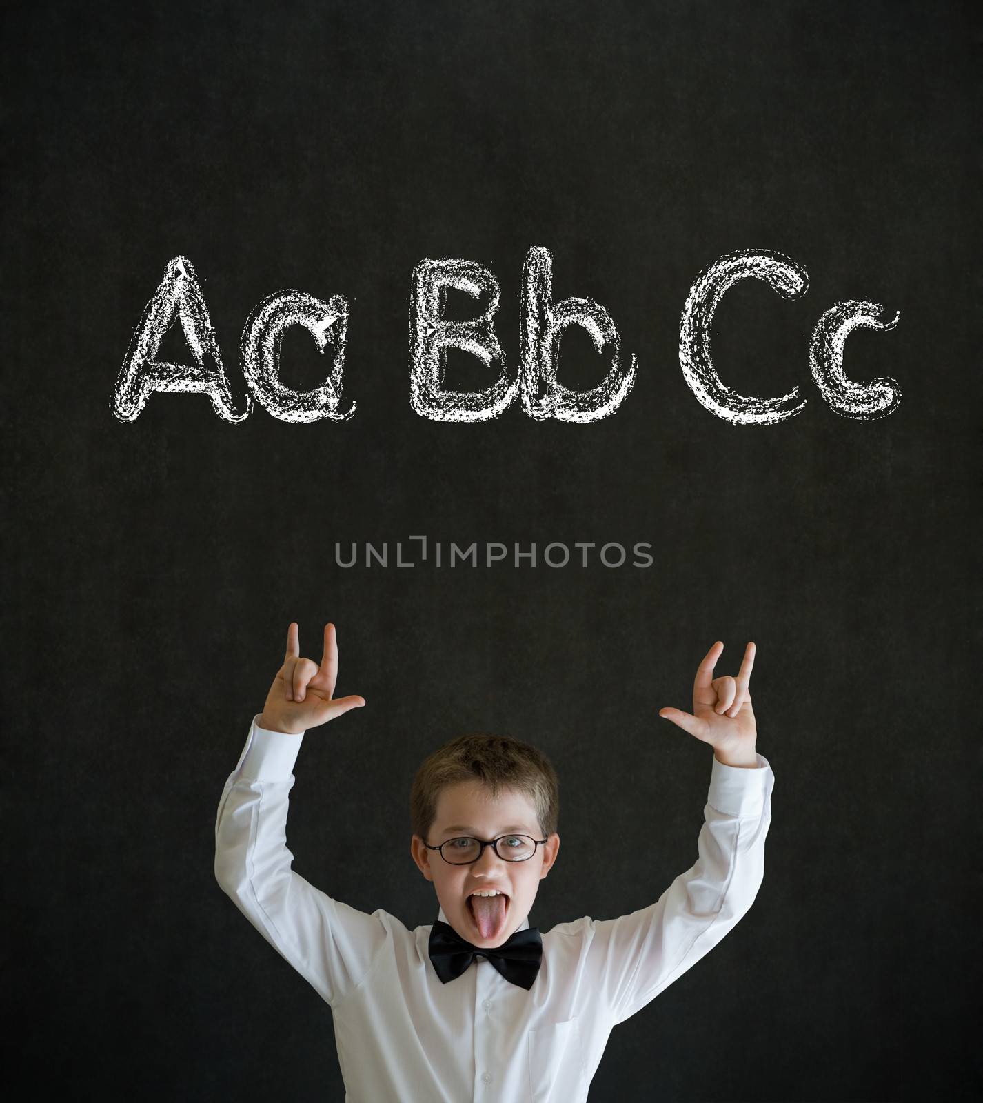 Knowledge rocks boy dressed up as business man with learn English language alphabet on blackboard background