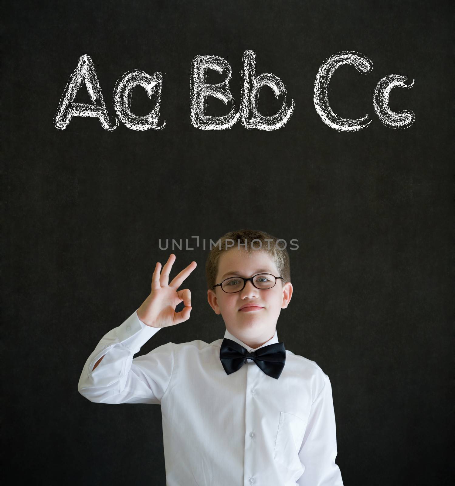 All ok or okay sign boy dressed up as business man with learn English language alphabet on blackboard background