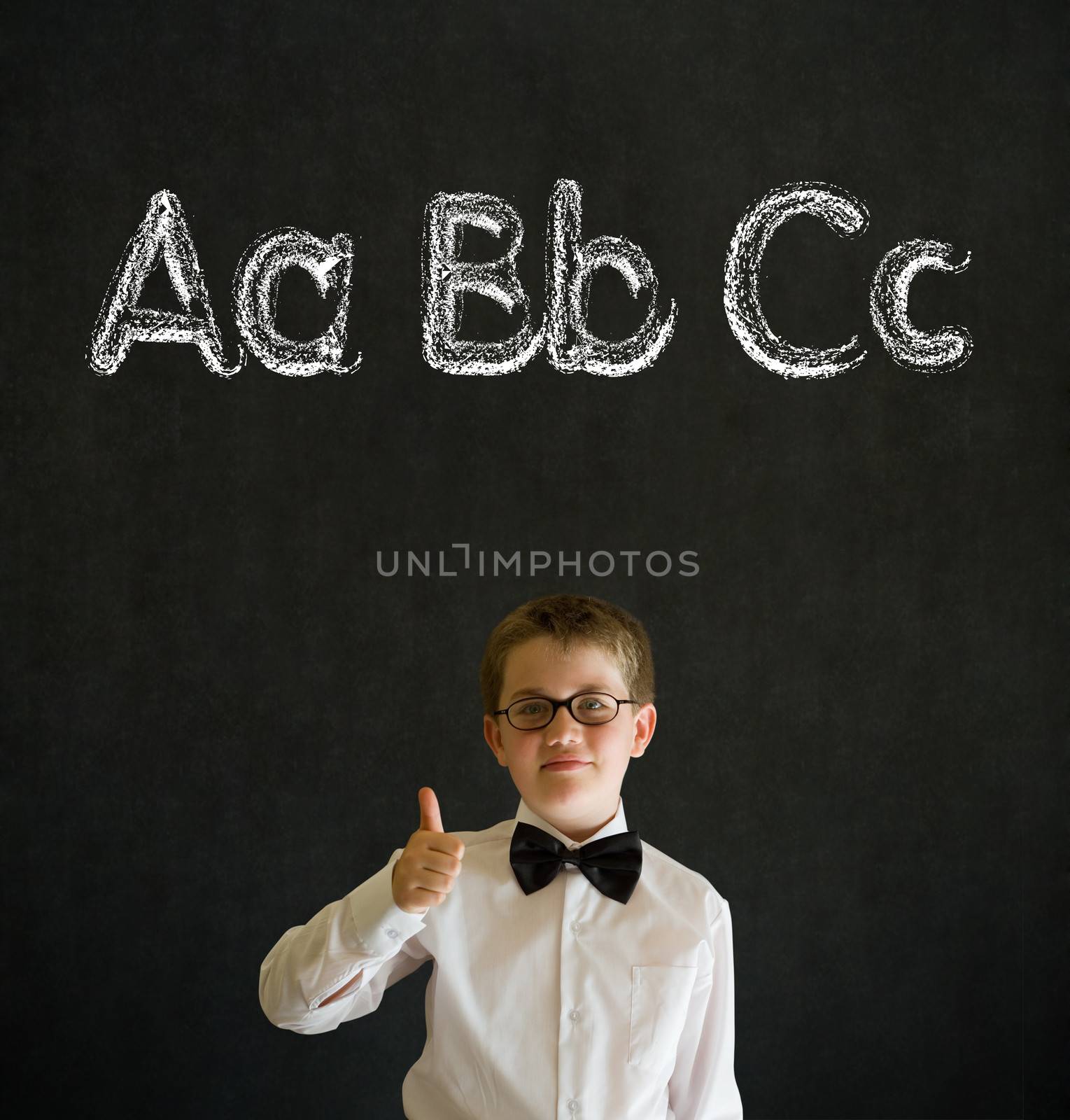 Thumbs up boy dressed up as business man with learn English language alphabet on blackboard background