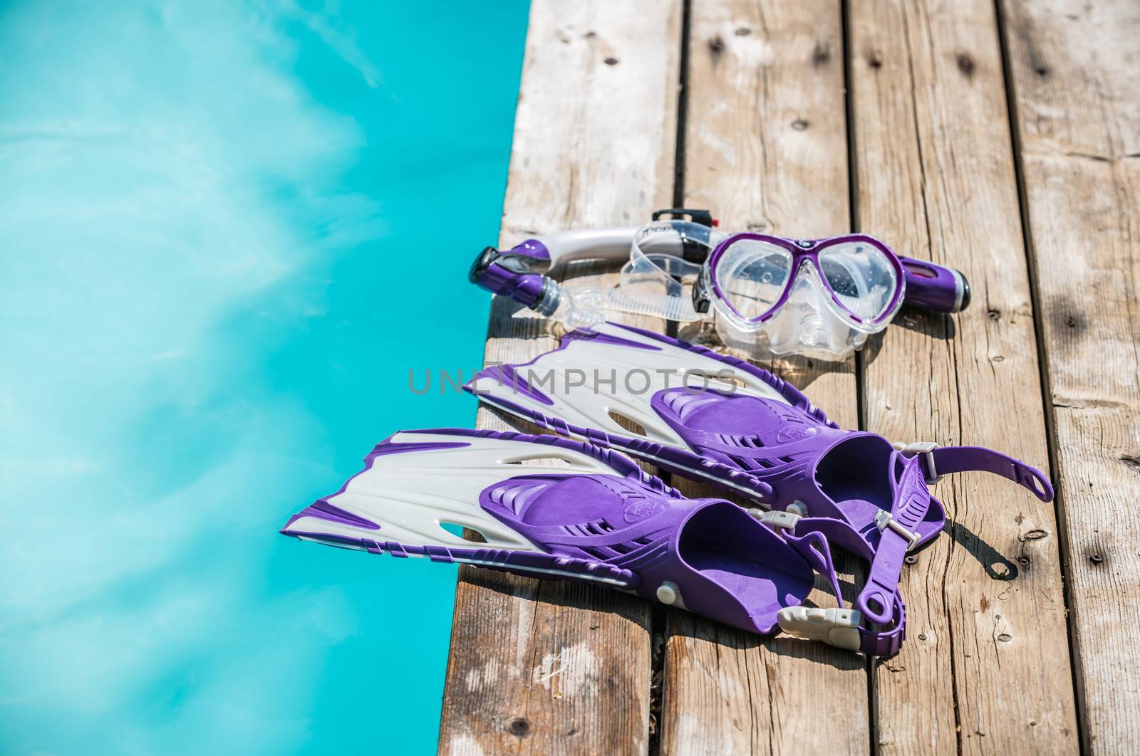 Diving goggles, snorkel and fins on the jetty by inarts