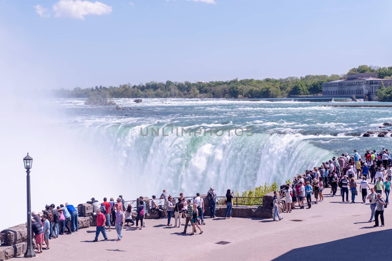 Niagara, Canada - May 16, 2013: Looking at Canadian side of the Niagara Falls on a sunny day. Tourists from all over the world are coming to see the waters falling off.