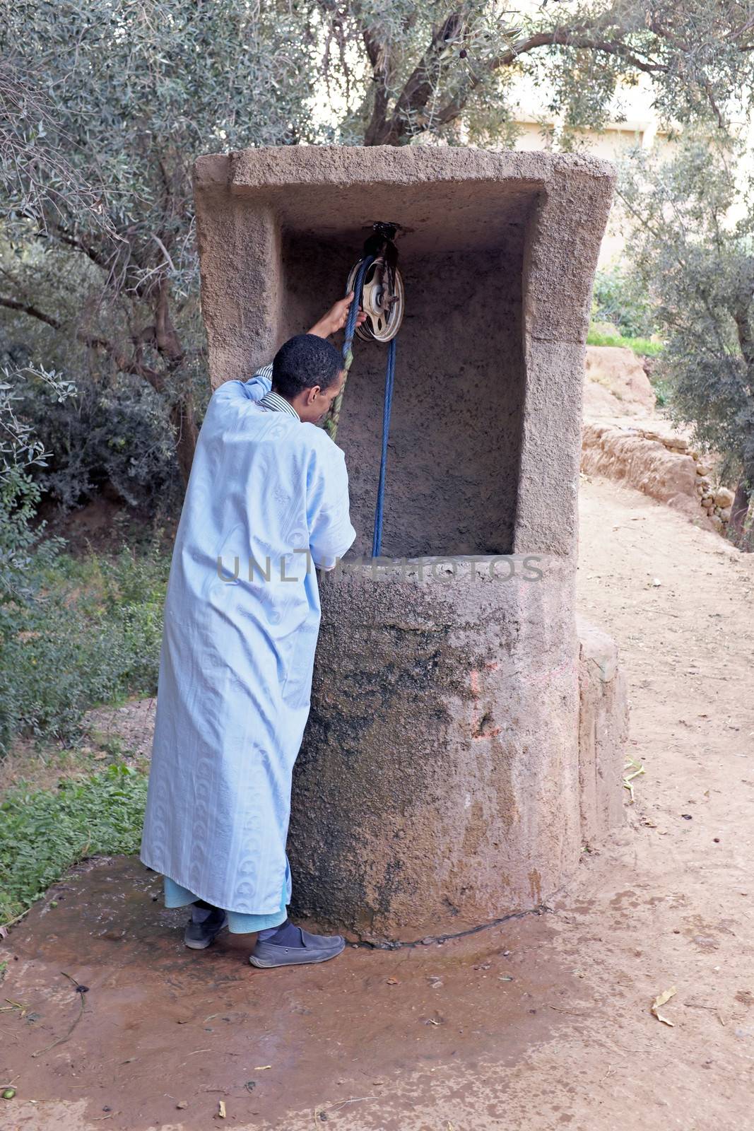SAHARA DESERT, MOROCCO 20 OCTOBER 2013: Man in traditional clothes drinking water from the well
