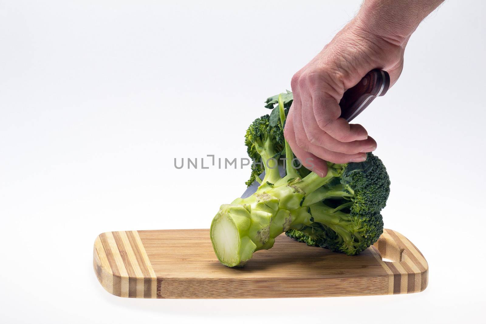 vegetable broccoli with  hand holding a knife on  white backround
