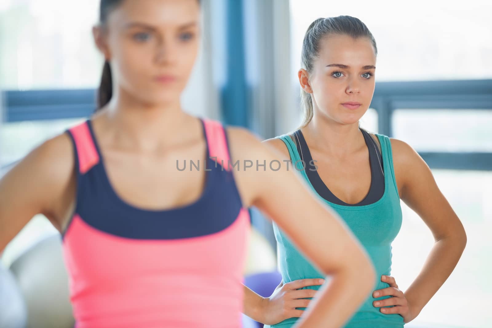 People standing with hands on hips at yoga class by Wavebreakmedia