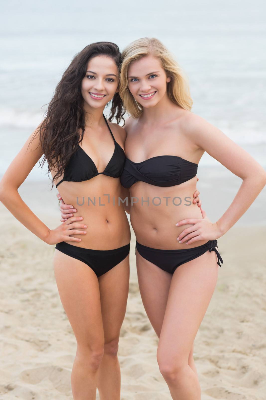 Smiling young bikini women at the beach by Wavebreakmedia