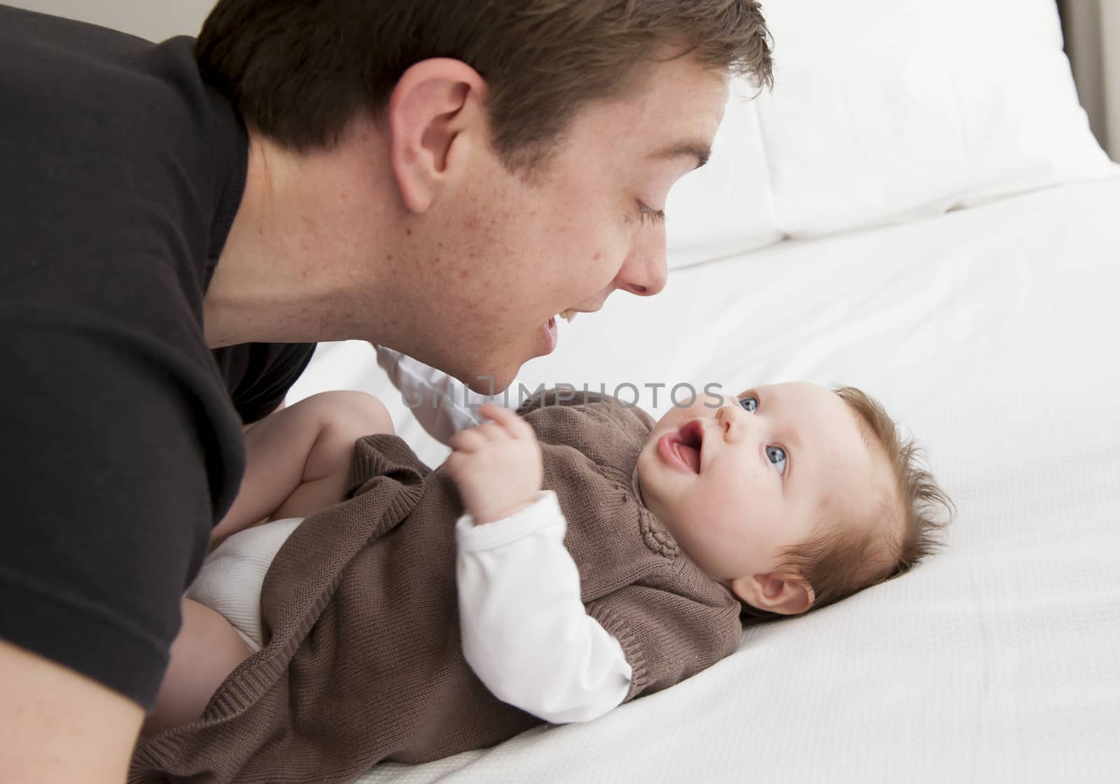 Young father playing with sweet baby girl at home