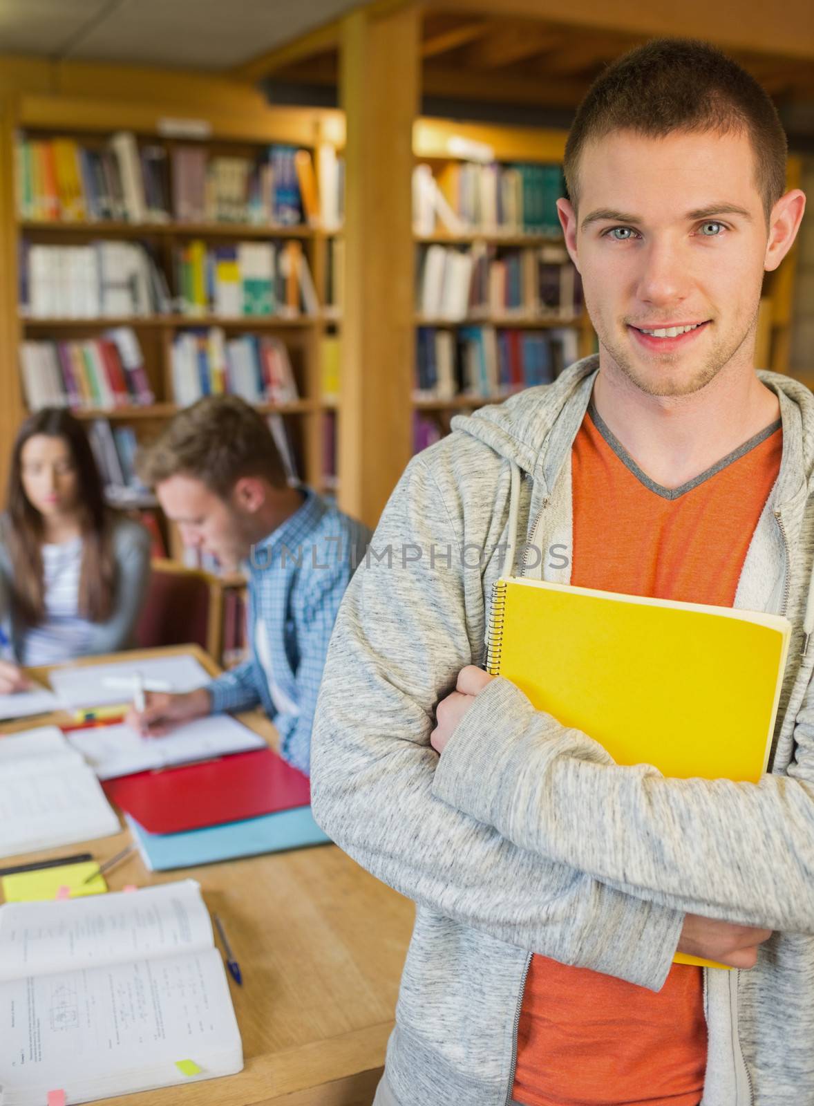 Male student with others in background at library by Wavebreakmedia