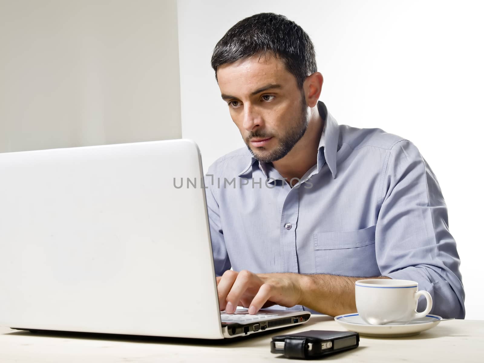 Young Man with Beard working on Laptop by ocusfocus
