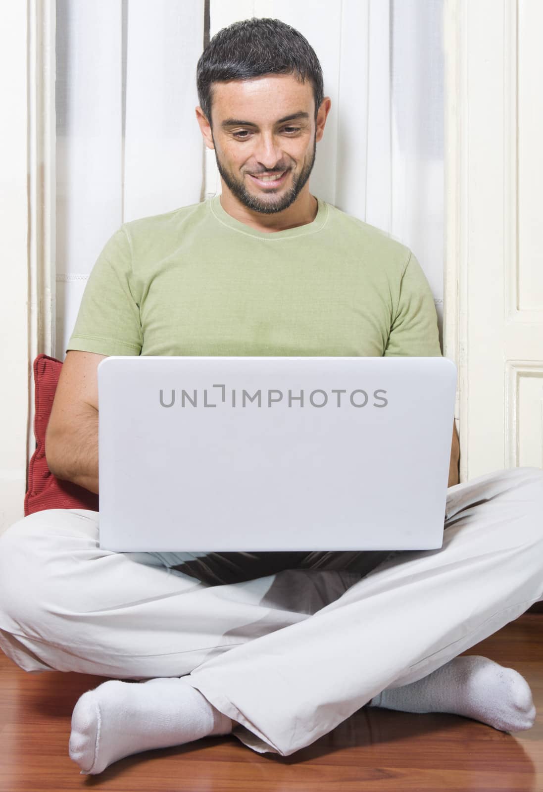 Happy Young Man Working on Laptop at Home 