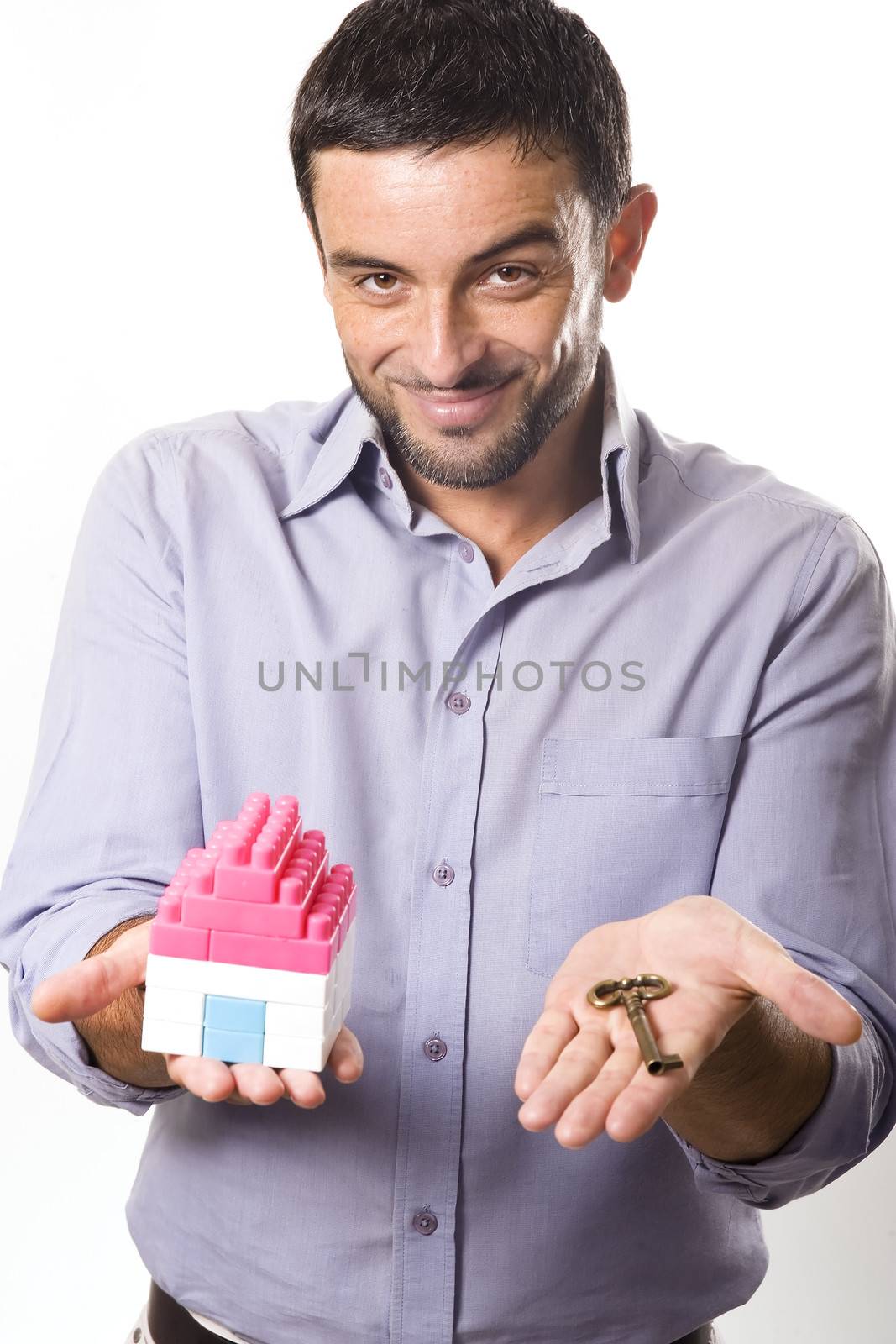 Young Man presenting Miniature House and Key by ocusfocus