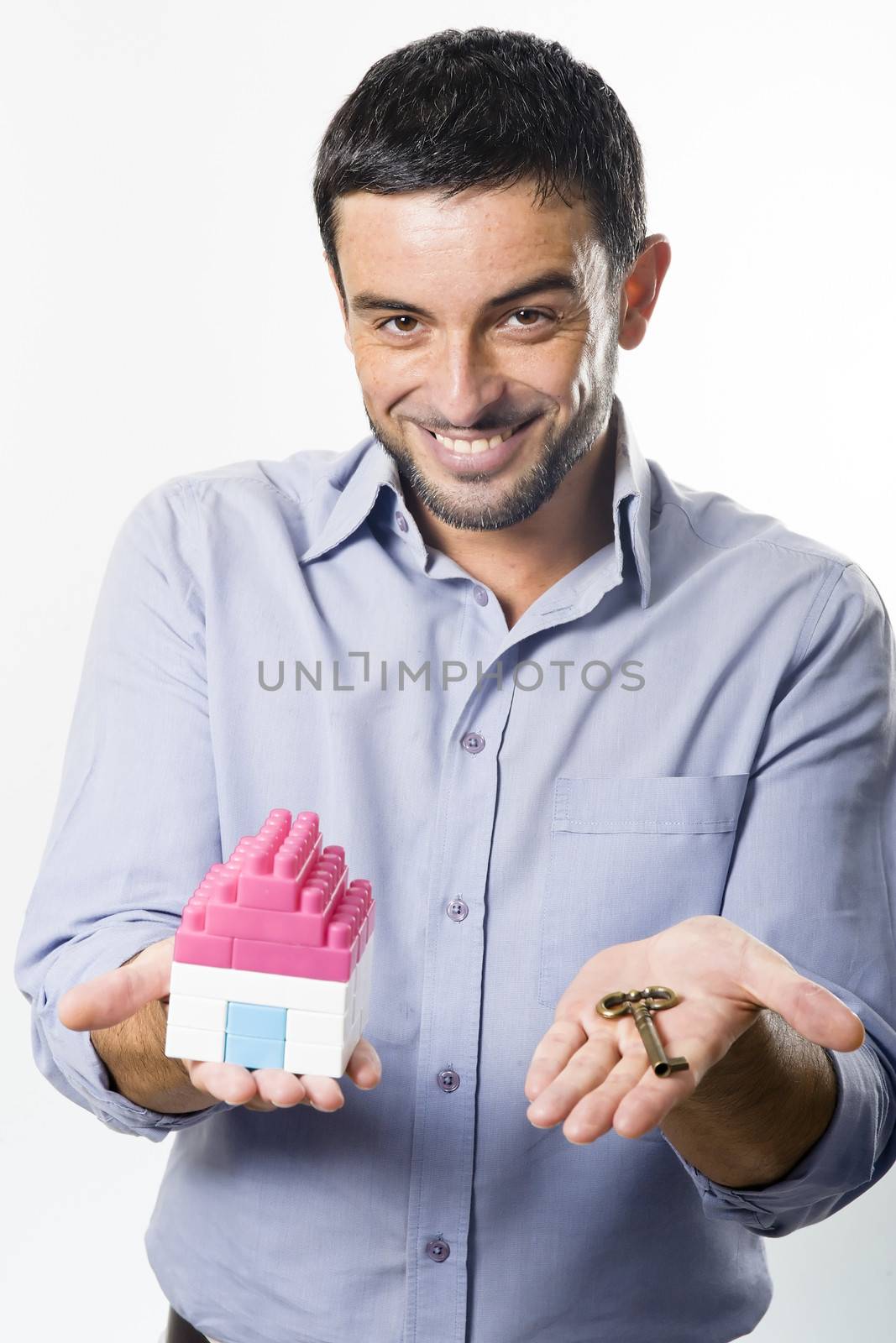 Young Man presenting Miniature House and Key by ocusfocus