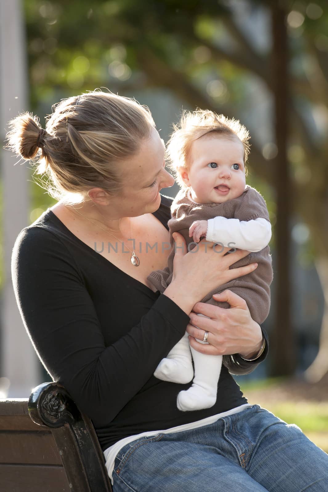 Young mother playing with sweet baby girl by ocusfocus