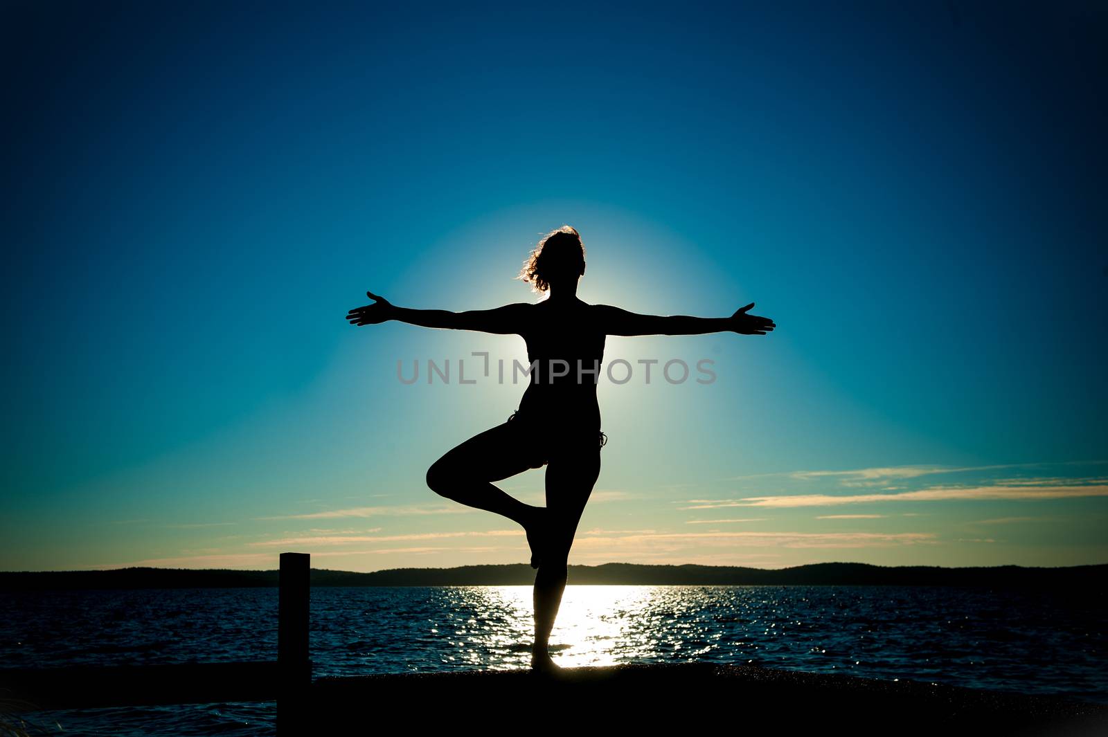Young Woman Silhouette Ballet with open arms dancing to the sea by ocusfocus
