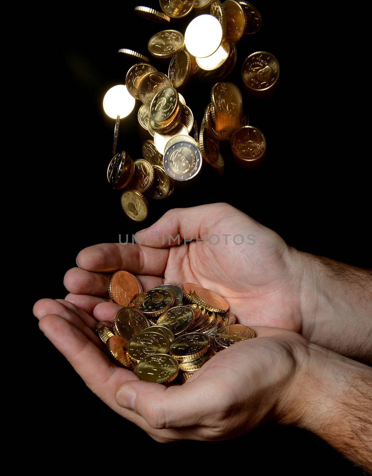 Man Hands full of money receiving a Rain of Coins isolated on black background