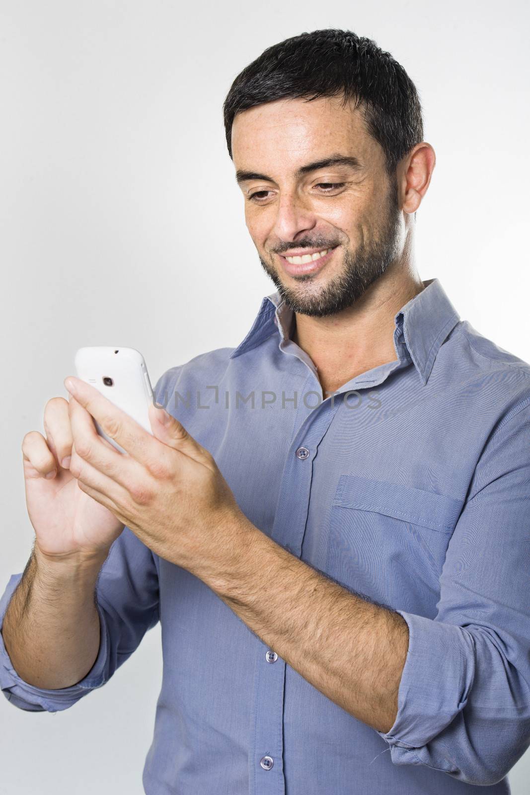 Happy Young Man with Beard texting on Cellphone isolated on White Background