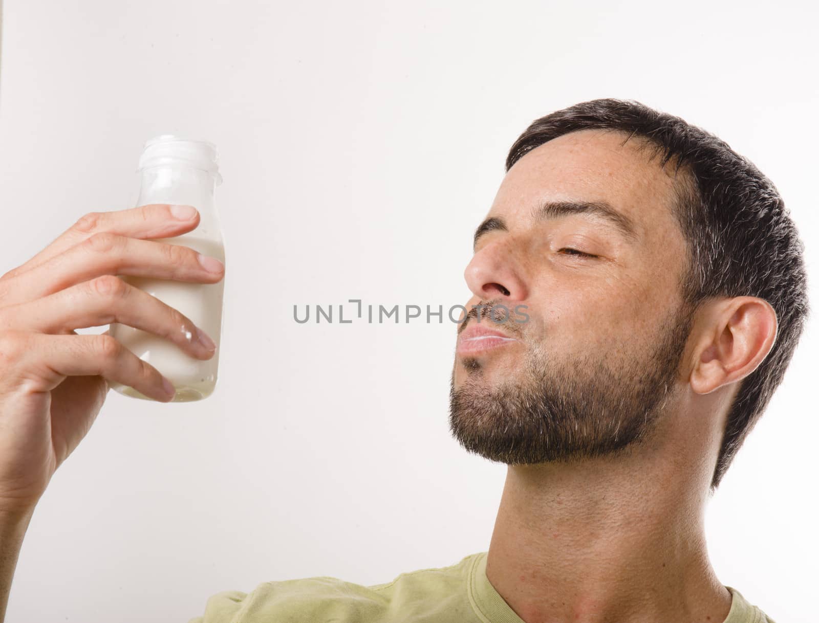 Young Handsome Man with Beard drinking Milk and Yogurt isolated on White Background